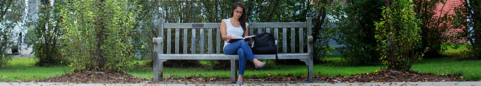 Giving Designations - Header Student on a bench in spring